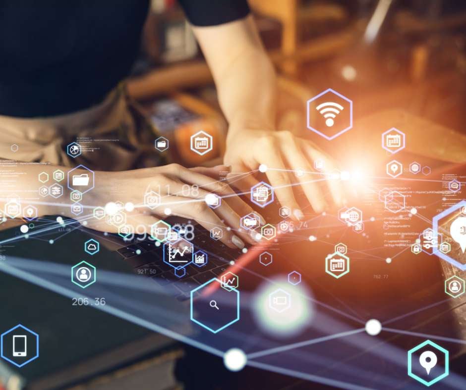Hands typing on a laptop with futuristic digital icons representing network connectivity, symbolizing Fluid IT's solution-based approach to system fortification and efficiency enhancement.