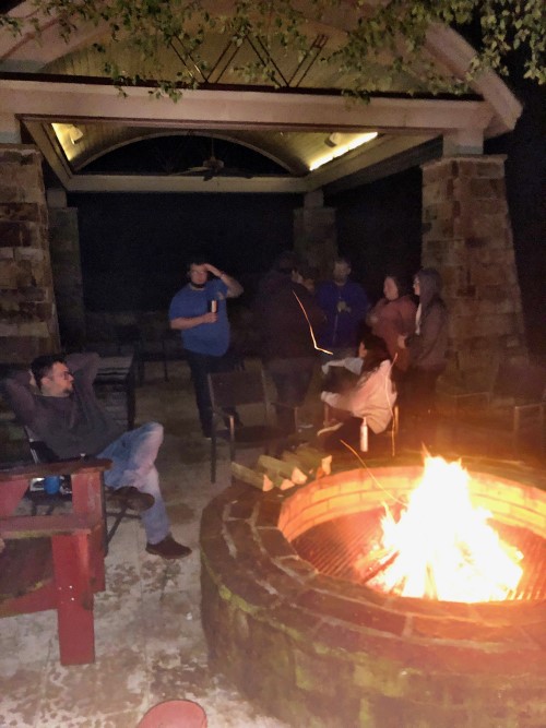A team of 8 people enjoying the chilly night around the fire place.